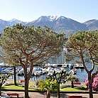 Vista di un porto con barche e montagne sullo sfondo.