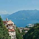 Panorama di un lago circondato da montagne e edifici storici.