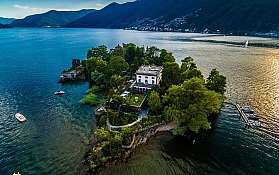 Insel mit Villa im Wasser Luftaufnahme einer Insel mit einer Villa und Booten im Wasser.