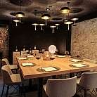 Sala da pranzo con tavolo in legno e illuminazione soffusa.