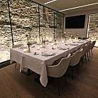 Interno di un ristorante con tavolo apparecchiato e pareti in pietra.
