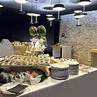 Un buffet elegante con antipasti, dolci e decorazioni floreali.