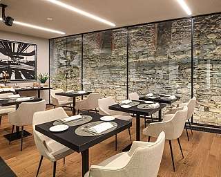 Ristorante elegante con tavoli e pareti in pietra.