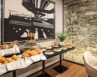 Un tavolo con vari dolci, pane e decorazioni in un ambiente elegante.