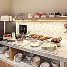 Area buffet con caffè, dolci e piatti decorativi.