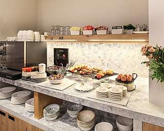 Un buffet con caffè, dolci e piatti per la colazione.