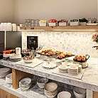 Area buffet con caffè, dolci e piatti decorativi.
