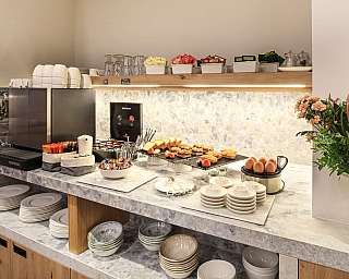 Un buffet con caffè, dolci e piatti per la colazione.