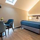 Interno di una camera con letto, tavolo e sedie eleganti.