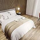 Interno di una camera con letto, tavolo e sedie.
