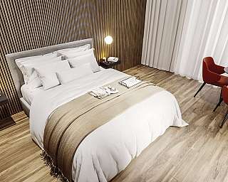 Interno di una camera da letto con letto e angolo lettura.