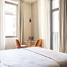 Interno di una camera con letto, tavolo e sedie.
