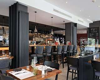 Stylish dining area with wooden tables and bar counter.